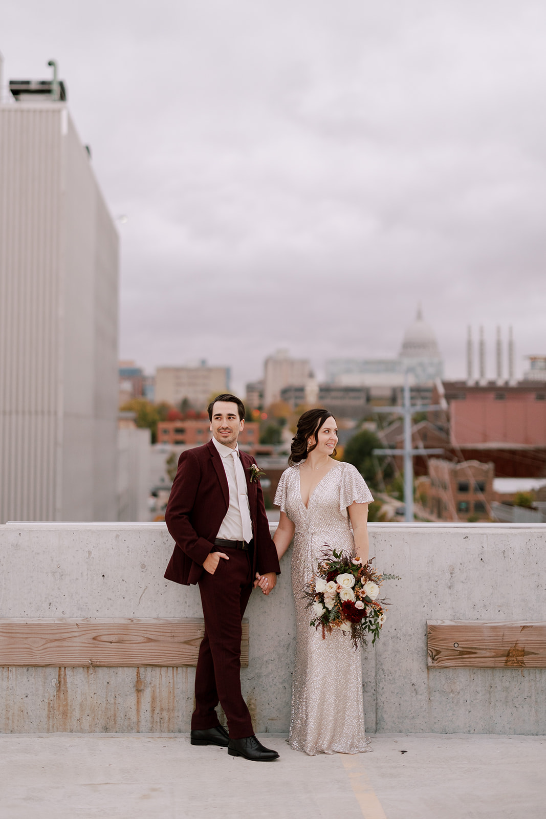 bride and groom stand on a rooftop in madison wisconsin on their intimate wedding day