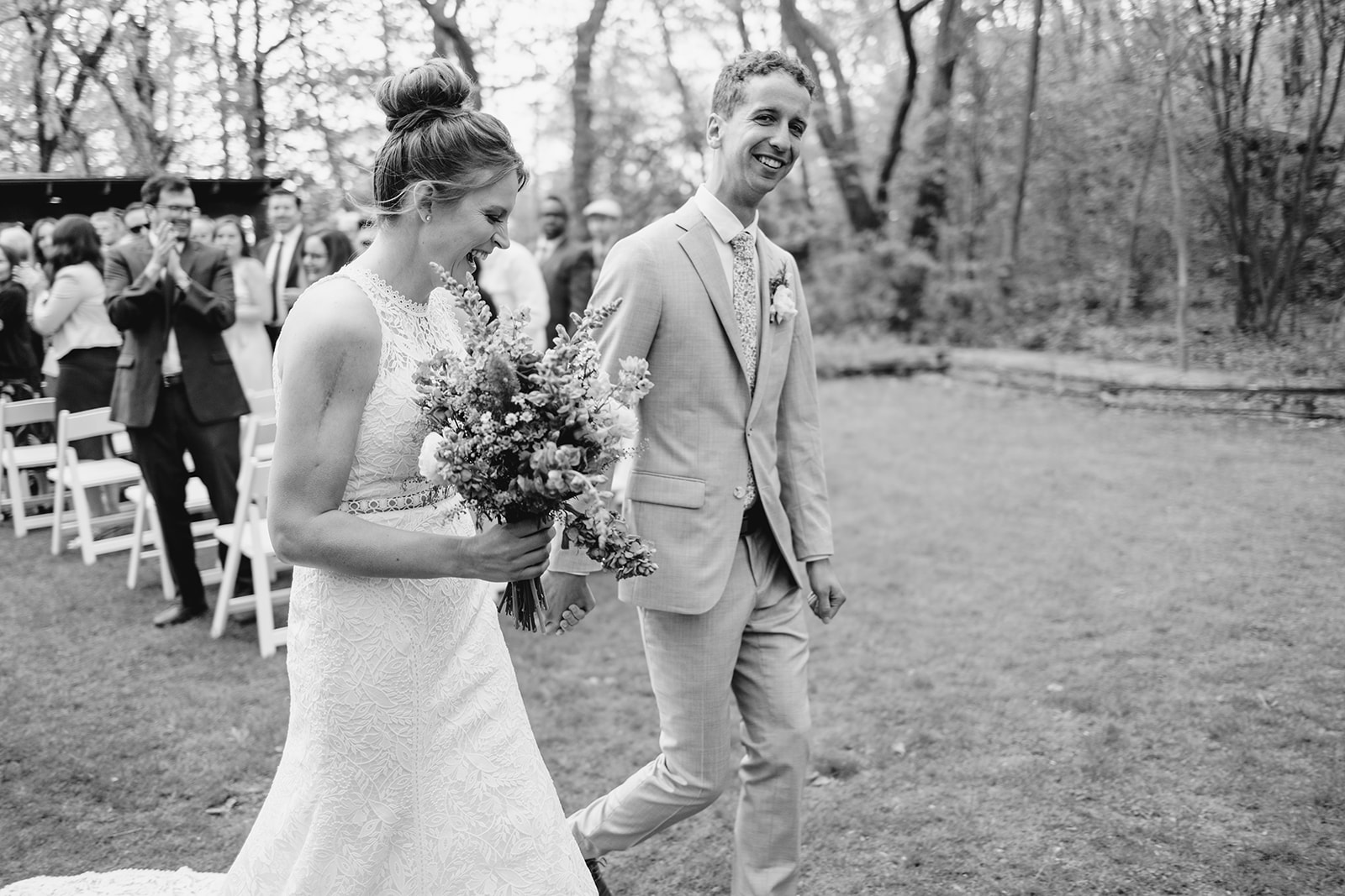 bride and groom walk down the aisle after they are pronounced husband and wife at the schlitz Audubon nature center in milwaukee