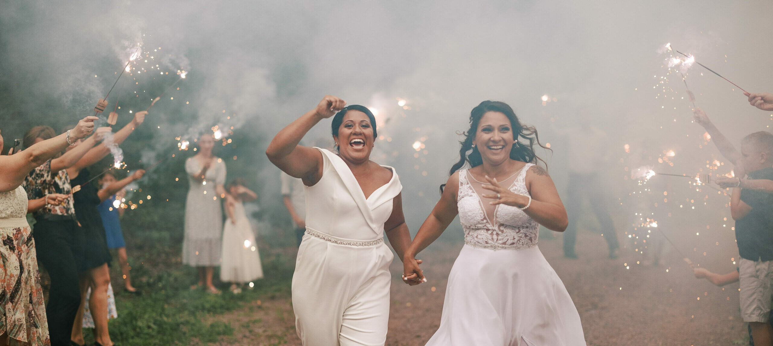 two brides run through sparklers on their wedding day