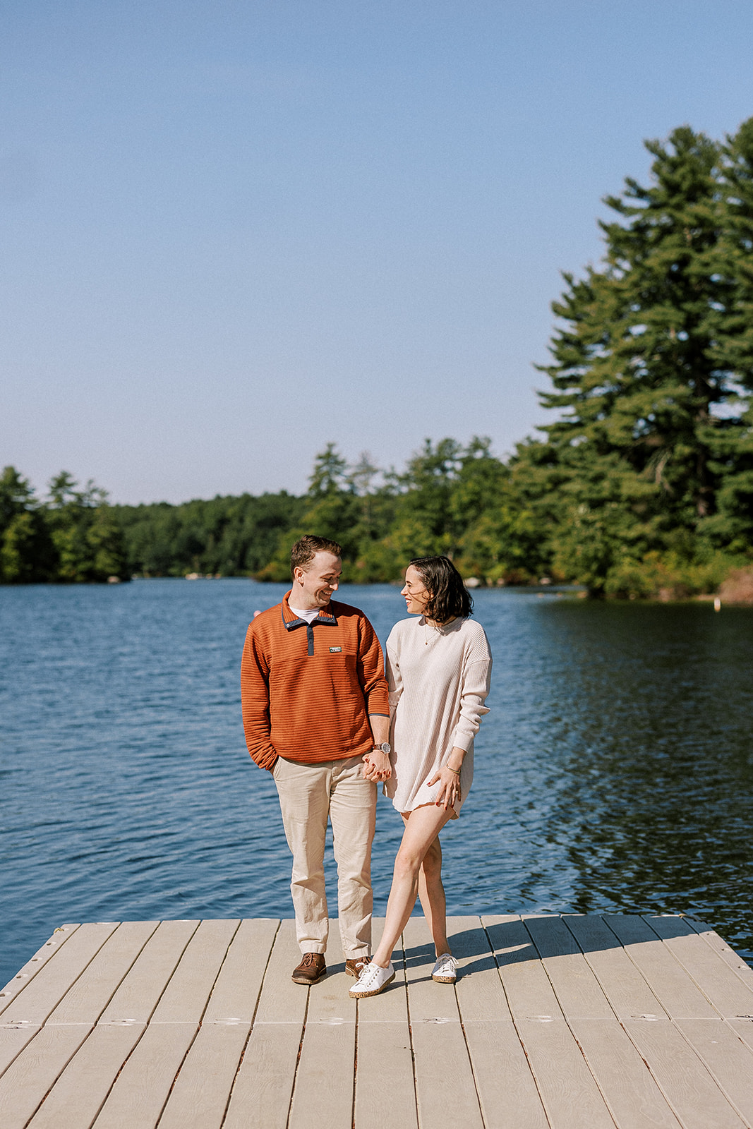 engaged couple stands on dock in rural Massachusettes during their engagement session