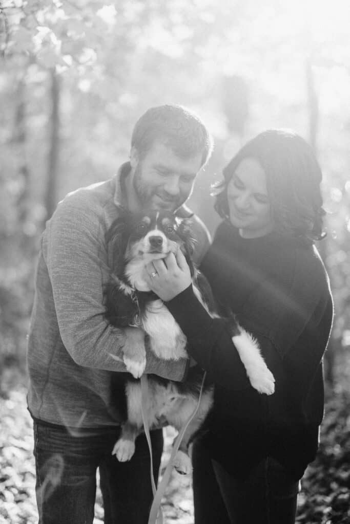 couple pets their dog during their engagement session in madison wisconsin