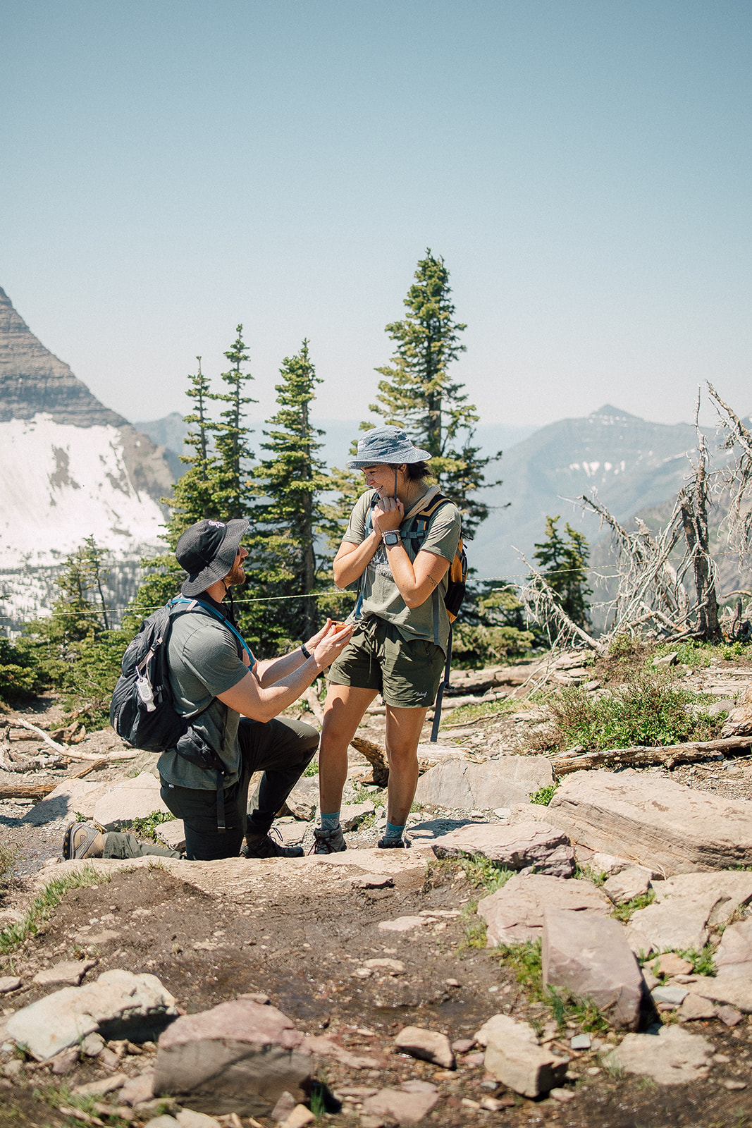 couple getting engaged in glacier national park at hidden lake