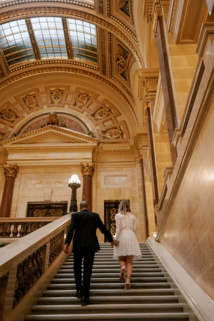 couple walks up stairs of capitol building in madison wisconsin during their elopement