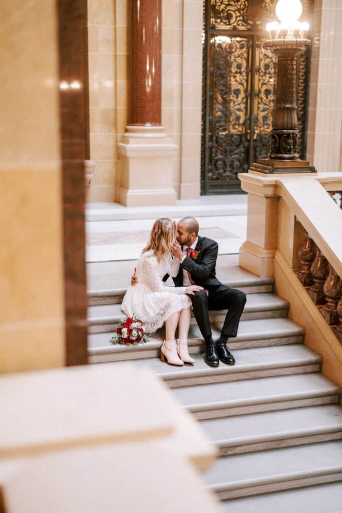 couple embraces on steps of madison capitol building during their intimate wedding