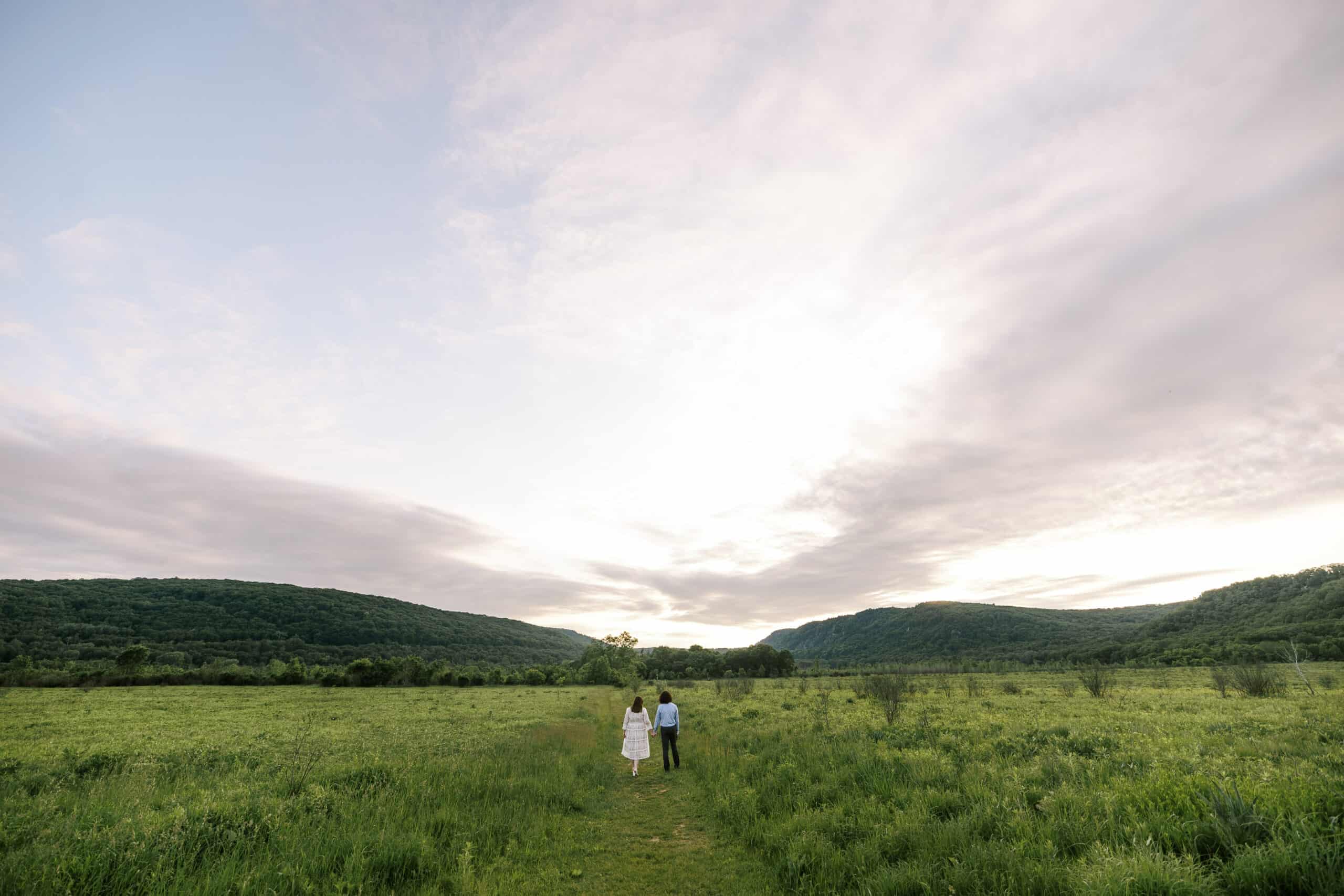 couple walks along a grassy path in the driftless hills of southern wisconsin