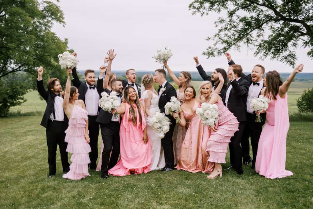 modern wedding party with mixed and matched pink floral dresses and black suits