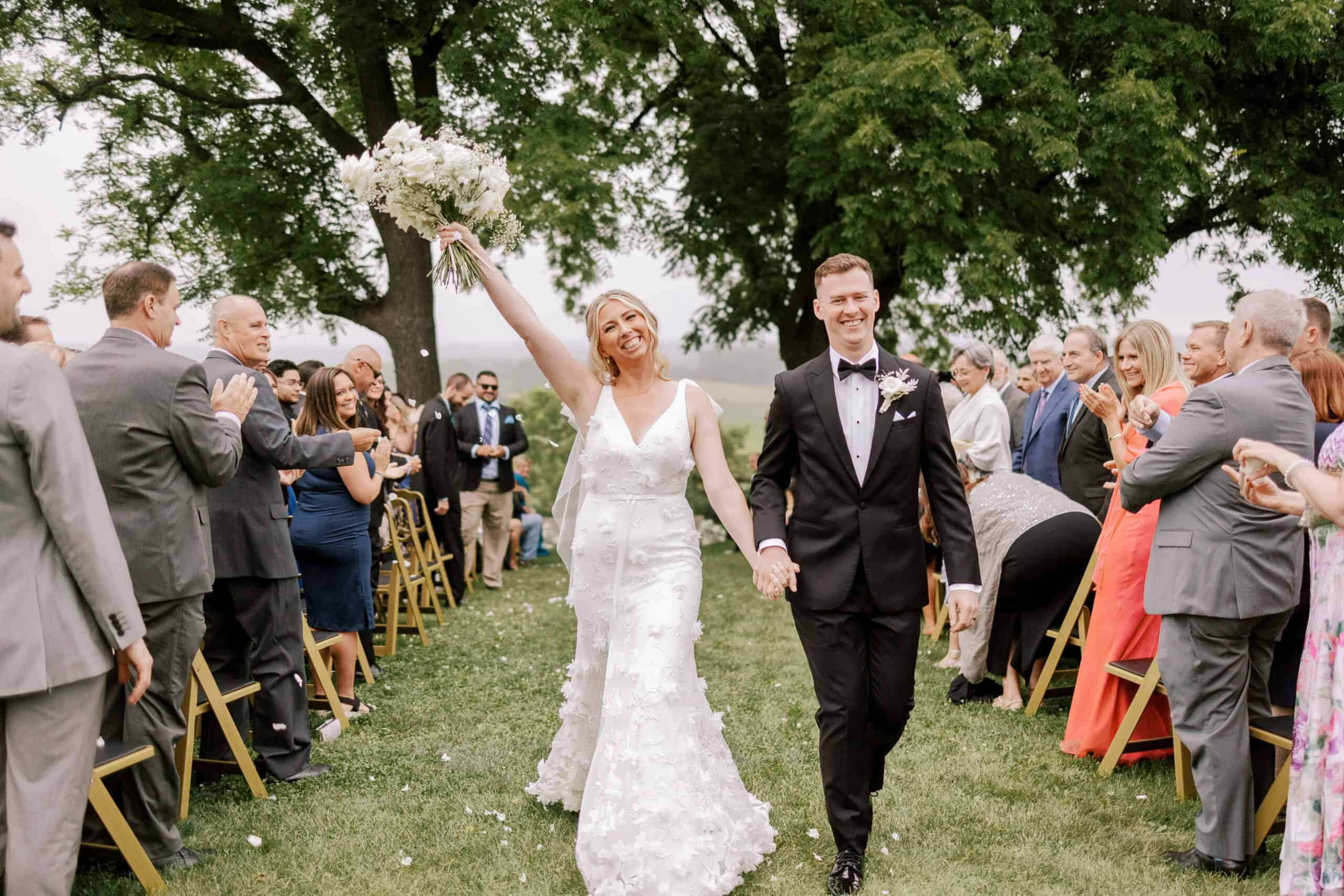 couple smiles as they walk down the aisle after being pronounced husband and wife at vennebu hill in baraboo, wisconsin