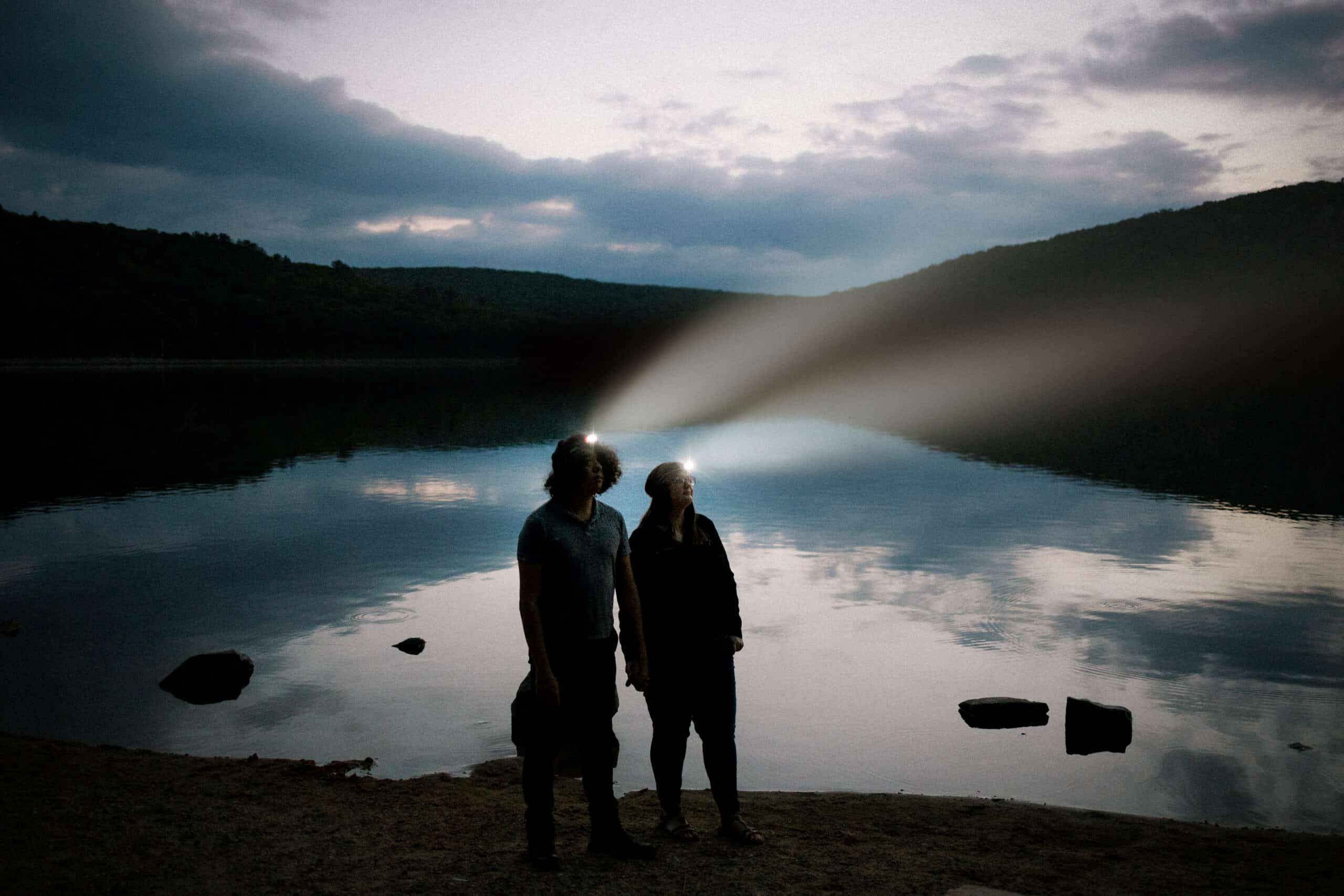couple looks into the sky with headlamps glowing at Devil's Lake in Baraboo, Wisconsin
