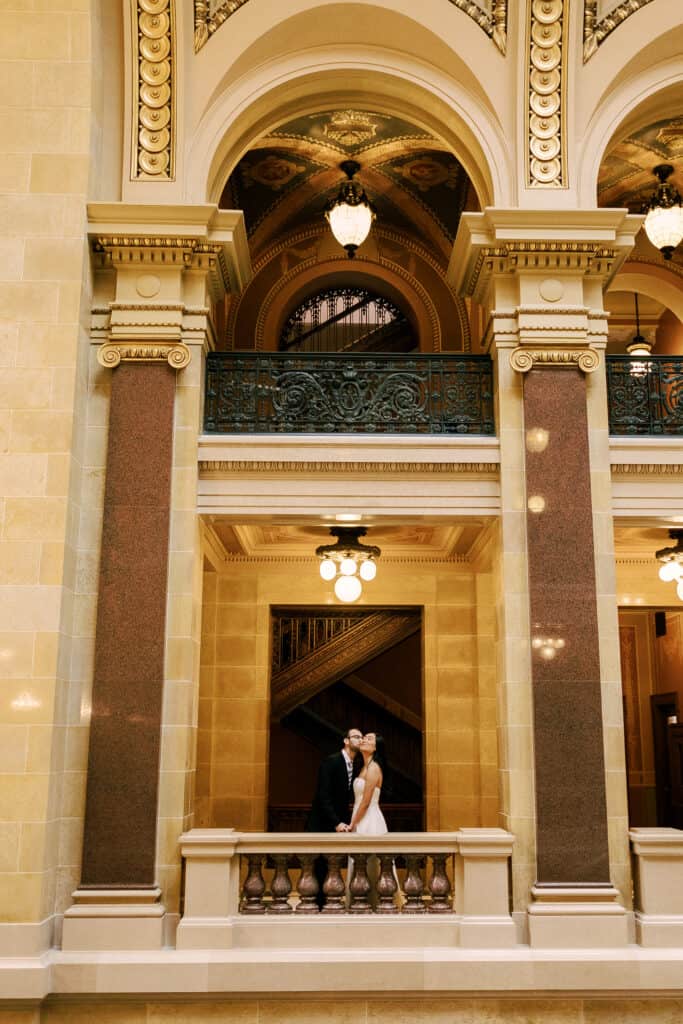 bride and groom kiss in the madison wisconsin capitol building before their intimate elopement