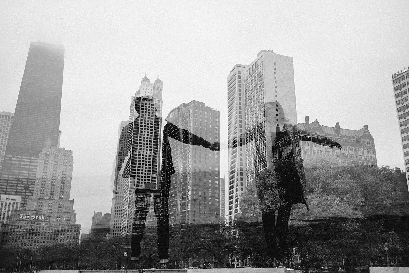 couple spins against the city skyline in a double exposure during their engagement session in chicago