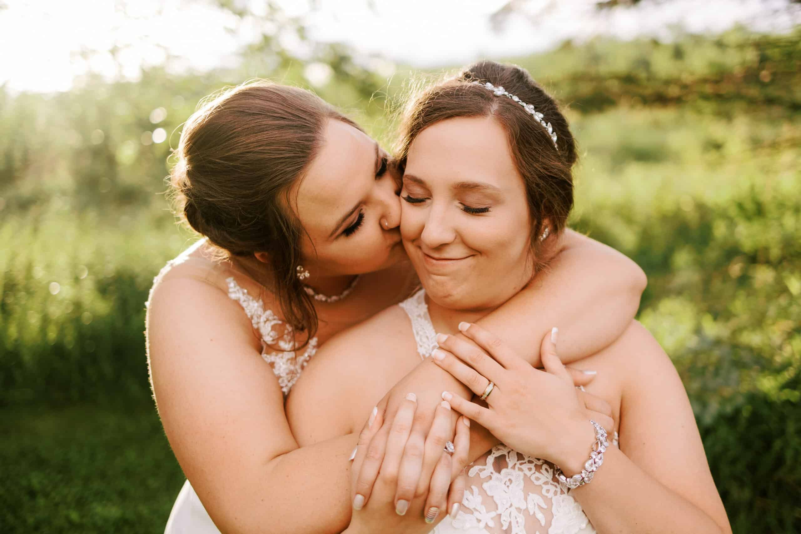 two brides embrace on their wedding day at rock ridge orchard in central wisconsin