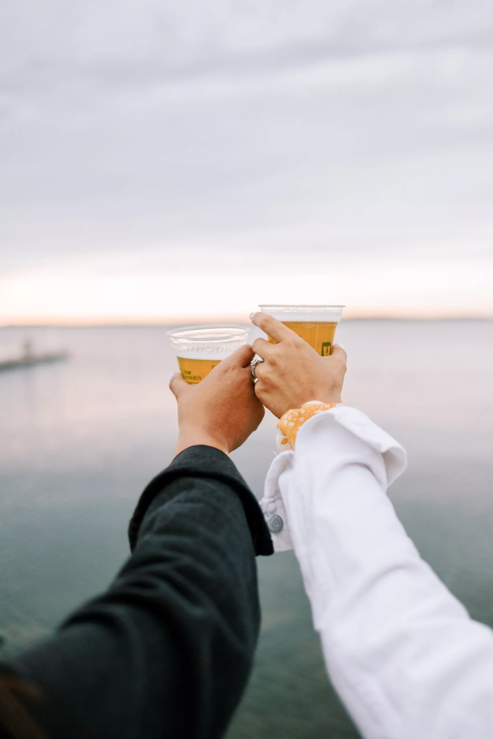 same sex couple enjoys beer at the UW Madison terrace during their engagement session