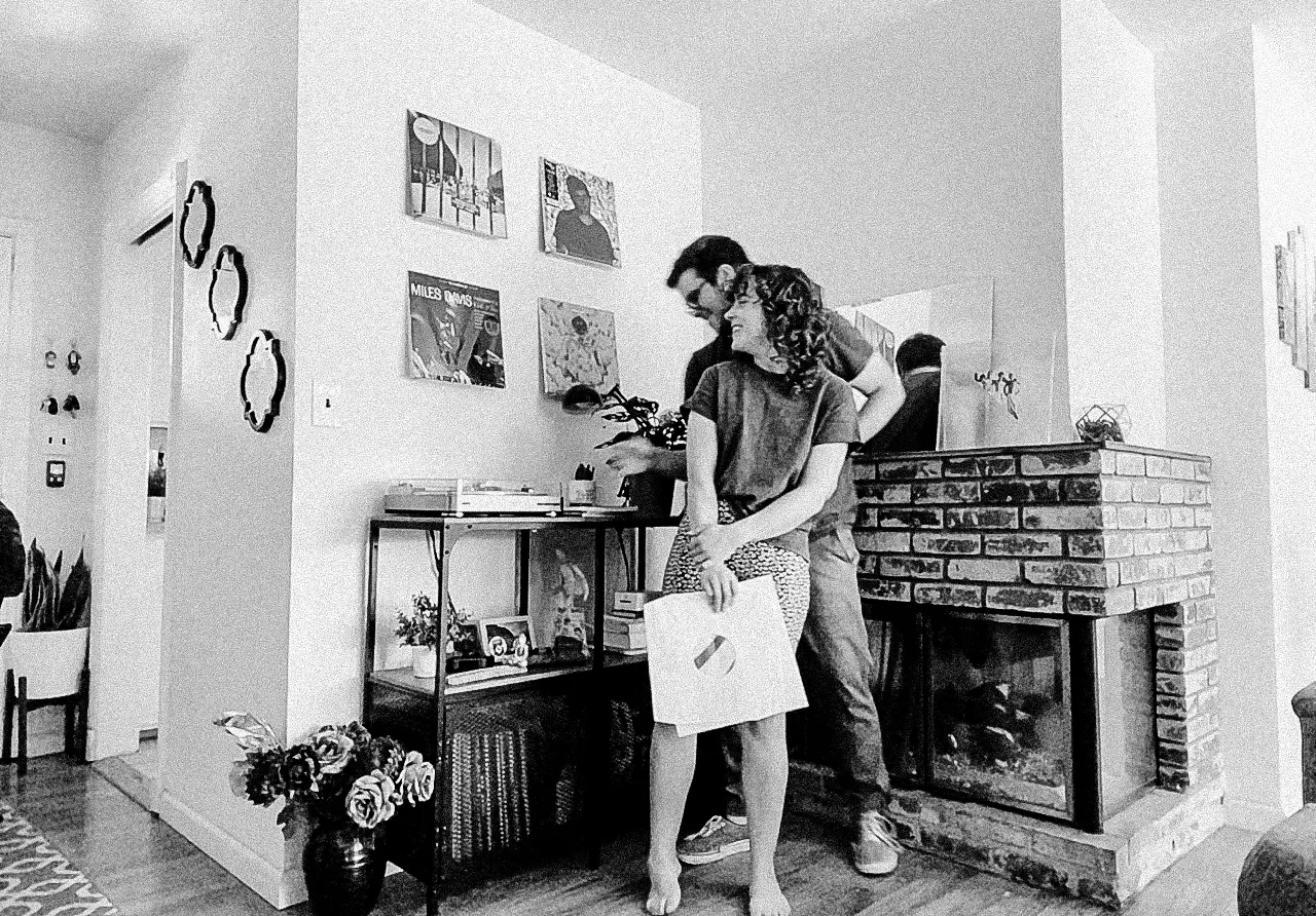 couple holds each other as they pick out records to play during their session