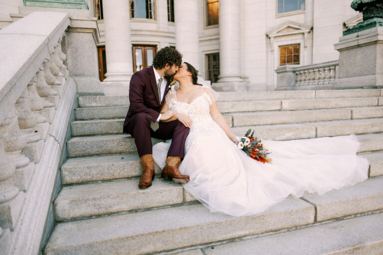 bride and groom embrace at the capitol building of wisconsin on their elopement day